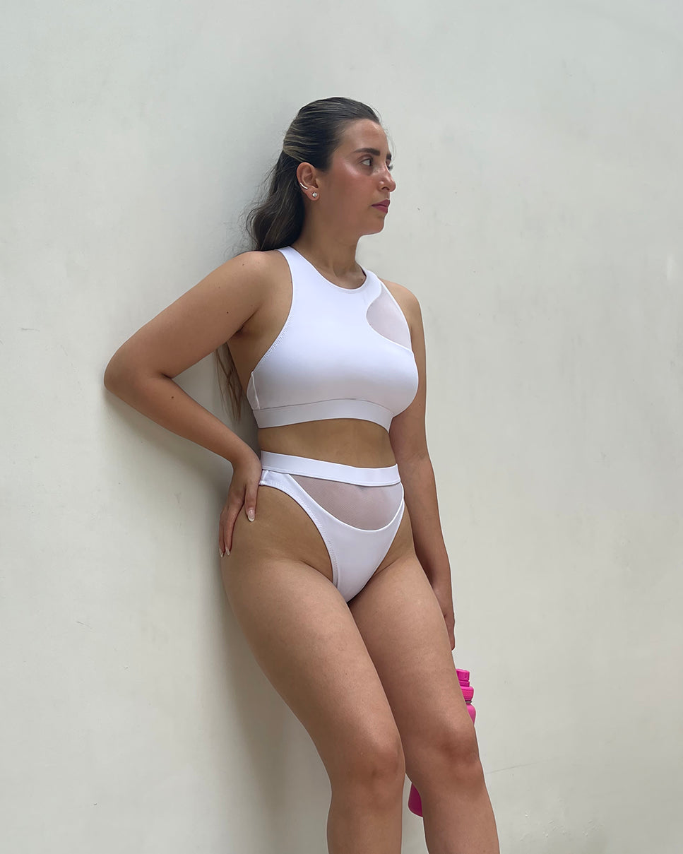 Darya bikini set by XY Swimwear. White color bikini. XY's Darya bikini features a sporty yet refined design with a semi-sheer mesh details. Sporty bikini. Activewear. Sports bikini. Athleisure. Singapore swimwear brand. Sustainable swimwear. Recycled fashion. Recycled Swimwear. Repreve fabric swimwear. Singapore based fashion brand. High fashion swimwear. High fashion bikini. vacation wear. Holiday wear. Holiday wardrobe. Resort wear. Sporty Swimwear. Sporty Bikini. Sporty Bikini. Sporty Swimwear.